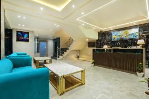 新德里OPO Hotels D'or的客厅配有蓝色的沙发和电视