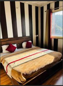 穆索里Hotel Maya Mussoorie - Near Mall Road - Luxury Room - Excellent Customer Service的一间卧室配有一张带红色枕头的大床