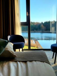 JaraczHotel Odpocznia Resort i Las的卧室设有窗户,享有湖景