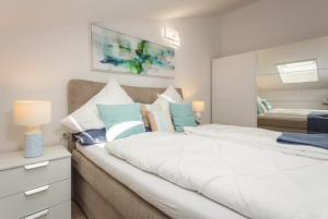 班约勒Luxury apartment Anto with sea view and balcony的一间卧室配有一张带蓝白色枕头的大床