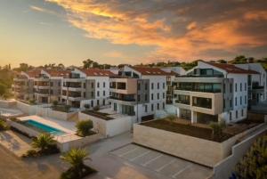 班约勒Luxury apartment Anto with sea view and balcony的一组白色公寓楼,享有日落美景