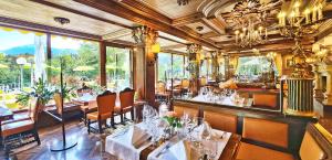 纳瑟莱特方恩斯坦湖城堡酒店的餐厅设有白色的桌椅和窗户。