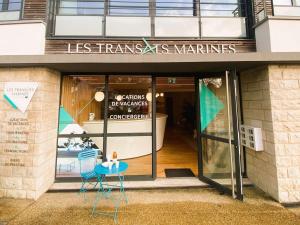 拉福雷富埃南Appartement La Forêt-Fouesnant, 3 pièces, 4 personnes - FR-1-481-121的前面的商店配有两把椅子和桌子