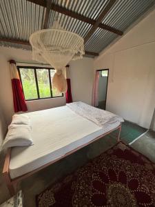 BhurkīāNanu's Bardiya Homestay的一间卧室配有一张带吊灯的床。