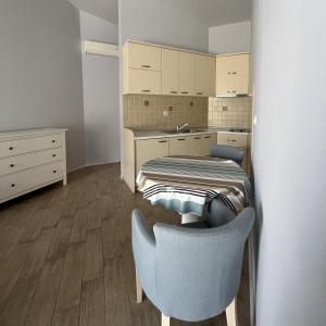 多布罗塔Turquoise Beachside Apartments的小房间设有一张床和一把椅子