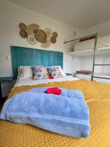 凯鲁Apto com vista mar no coração de Morro de SP的卧室配有蓝色毯子,位于床上