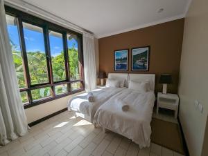 伊甸岛Maison Bigorno by Simply-Seychelles的一间卧室设有一张大床和大窗户