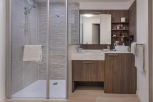瓦朗西纳Domitys l'Esquisse的带淋浴、盥洗盆和镜子的浴室