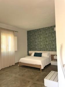 兰佩杜萨B&B SoleLuna的卧室配有白色的床和绿色的墙壁