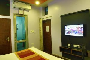 卜山Shaleen Elegance Homestay Nakki Lake 400 meters的一间卧室配有一张床和一台平面电视