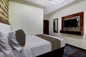 维沙卡帕特南Collection O B SQUARE VILLA的一间卧室配有一张床和一台平面电视