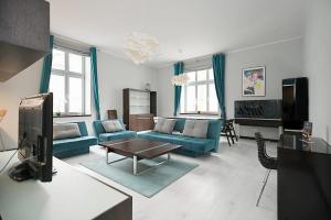索波特Victus Apartamenty, Apartament Niebieski的客厅配有蓝色的沙发和电视