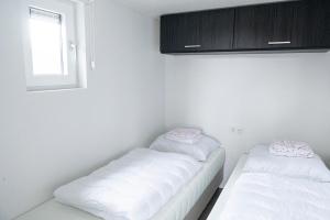 哈尔德韦克Camping de Konijnenberg Tiny House的带窗户的客房内的2张白色床
