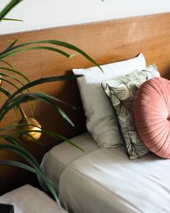 博克斯梅尔特菲尔特里克酒店的一张带木制床头板的床铺,配有枕头和植物