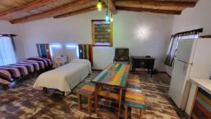 蒂尔卡拉La Posada del Rio的客房设有两张床、一张桌子和一台冰箱