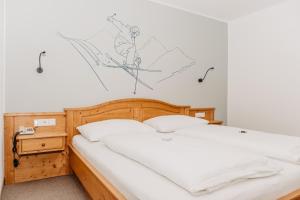 上陶恩Hotel Grünwaldkopf的卧室内的一张床铺,墙上绘有画