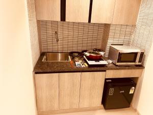 古尔冈The Lodgers 2 BHK Serviced Apartment Near Artemis Hospital Sector 57 Gurgaon - Nearest Metro Station Sector 54 Chowk的一间带水槽和微波炉的小厨房