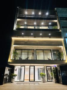 古尔冈The Lodgers 2 BHK Serviced Apartment Near Artemis Hospital Sector 57 Gurgaon - Nearest Metro Station Sector 54 Chowk的一座建筑,设有两个阳台,上面有盆栽植物