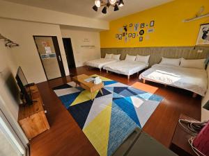 马公澎湖紙飛機民宿Paper Jet B&B的一间设有两张床的房间和一张色彩缤纷的地毯
