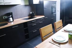 比勒费尔德3-Zimmer-Oase-Cityapartment Bielefeld Mitte 201的厨房配有黑色橱柜和桌椅