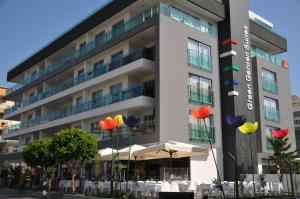 阿拉尼亚绿色花园套房酒店的一座建筑前面有五颜六色的雨伞