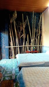 芹苴Cần Thơ Farmstay的一间卧室设有两张床和壁画墙