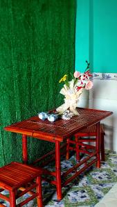 芹苴Cần Thơ Farmstay的一张木桌,上面有花瓶