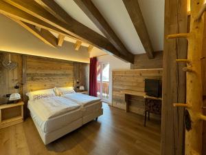 拉瓦罗内阿拉戈酒店的一间卧室设有一张床和木墙