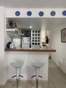 伊塔帕里卡岛维拉克鲁兹Flat aconchegante à beira-mar的厨房在柜台前设有两张凳子