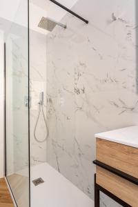 乌迪内Residence Moretti Piano Terra的一间铺有白色大理石的淋浴浴室