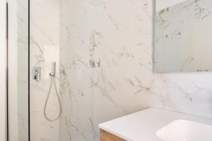 乌迪内Residence Moretti Piano Terra的带淋浴和盥洗盆的白色浴室