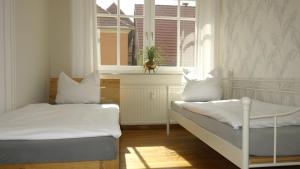 普劳西Ferienwohnungen Altstadt的带窗户的客房内的两张床
