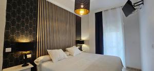 内尔哈Hostal Luna de Nerja HMA 02340的卧室配有白色的床和黑色墙壁