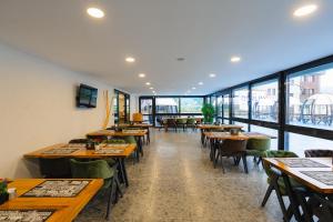 特拉布宗Berlin Suite Hotel Trabzon的餐厅设有木桌、椅子和窗户。