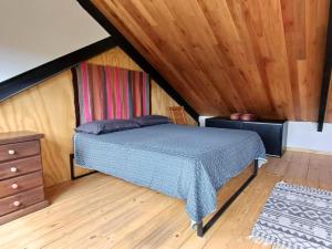 圣马丁德洛斯Casa de montaña La Cumba Patagonia.的一间卧室设有一张床和木制天花板