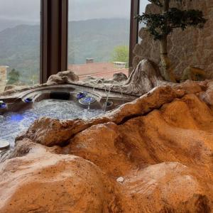 维埃拉·多米尼奥Pousadela Village的窗户前带大岩石的热水浴池