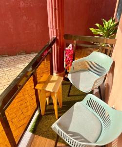 科纳克里Tokyo to Conakry *NONGO*的阳台配有两把椅子和一张桌子,种着鲜花