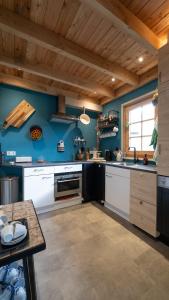 贝斯特Best Boerderij B&B的厨房拥有蓝色的墙壁和木制天花板