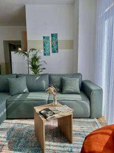 格勒姆Gibel Apartments的客厅配有蓝色的沙发和茶几