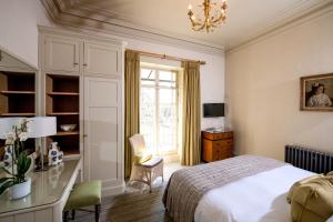 巴斯巴斯小修道院 - 丽莱斯城堡酒店的一间卧室配有一张床、一张书桌和一个窗户。