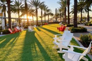 哈兰代尔海滩Enjoy our brand new home close to Hollywood in Hallandale Beach!的草地上种有椅子和棕榈树的公园