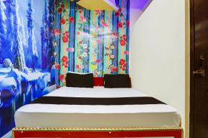 新德里OYO Golden Moment Guest House的一间卧室配有一张带色彩缤纷窗帘的床