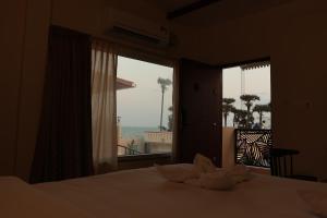 蓬蒂切里PALM PARADISE Beach Resort的一间卧室配有一张床,享有海景