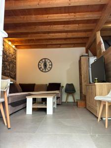 蒂瓦特Bay House Kakrc的客厅配有沙发和墙上的时钟