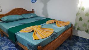 亭可马里KANTHI GUEST INN的一间卧室配有一张床,上面有两条毛巾