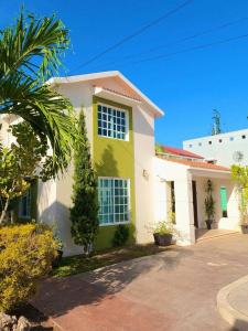 切图马尔Casa Coccoloba, Chetumal, Quintana Roo的棕榈树的黄色和白色房子