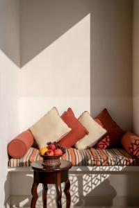麦纳麦索菲特巴林匝拉塔拉萨海水疗酒店的一张带枕头的沙发以及一张带水果的桌子