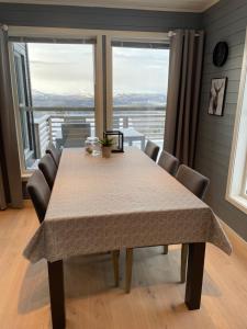 BergsetCabin - Målselv fjellandsby的餐桌、椅子和大窗户