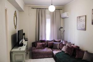 弗洛里纳Lucato apartment的客厅,窗户前配有紫色沙发