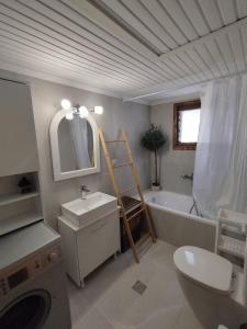 卡罗维西Laki's House的浴室配有盥洗池、卫生间和浴缸。